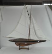 A Nauticalia wooden model of a sailing boat, on stand, bearing metal plaque,