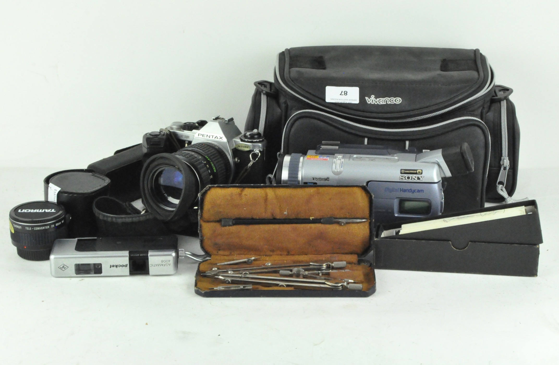 A collection of assorted cameras and lenses, including a AGFAmatic 4008, Tamron 521513 lens,