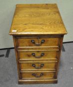 A small oak reproduction lockable chest of drawers with two small drawers above one double-front