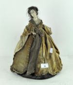 A vintage tea cosy, modelled as a woman in 18th century style velvet gown,