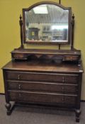 A large Victorian oak dressing table with three long drawers and swing mirror with arched top above