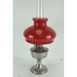 A vintage Super Aladdin oil lamp with original red and white glass shade and clear funnel
