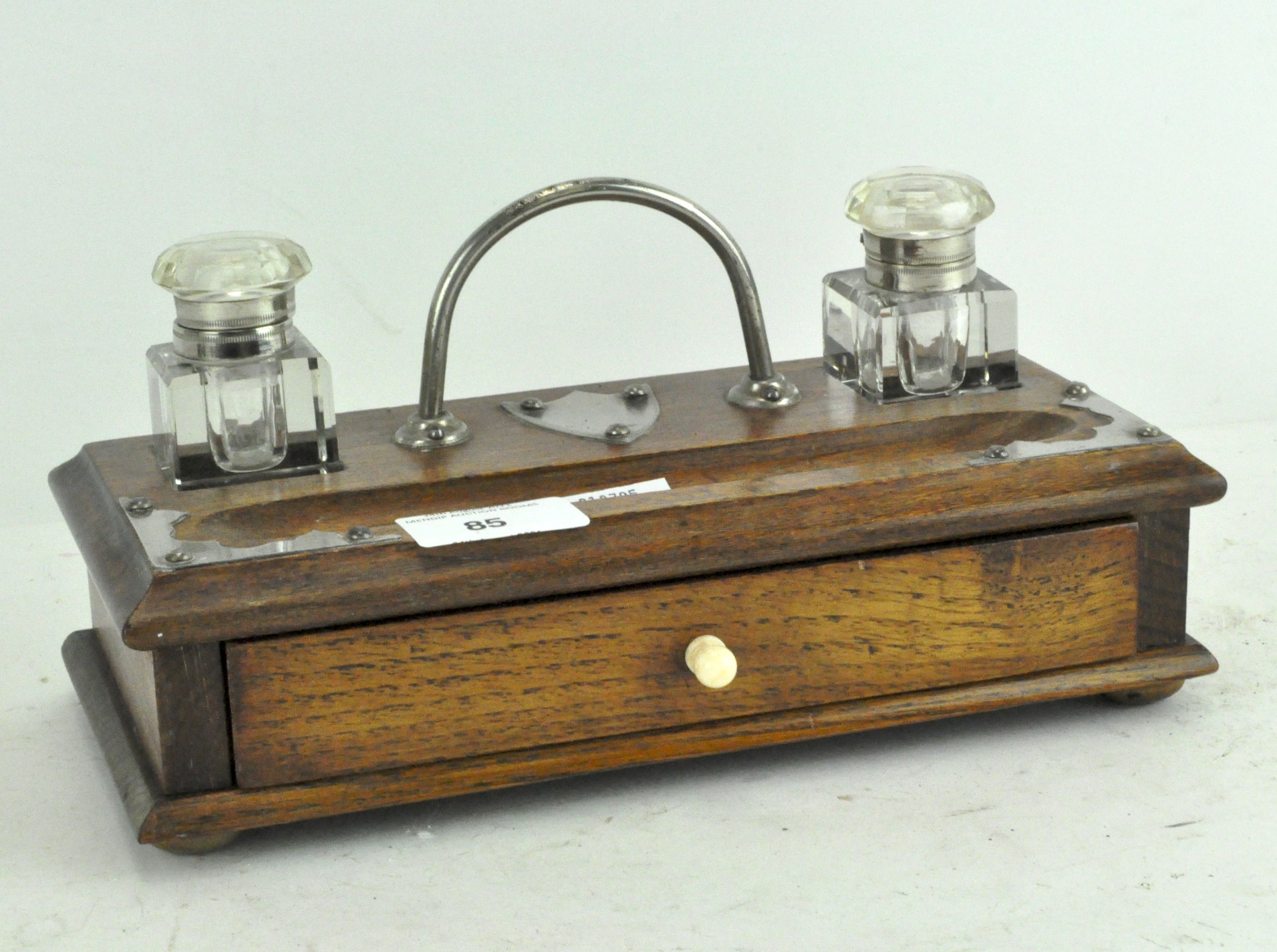 An Edwardian oak and metal-mounted desk set of rectangular form, with two glass inkwells,