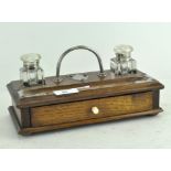 An Edwardian oak and metal-mounted desk set of rectangular form, with two glass inkwells,