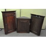 Three Edwardian mahogany corner cabinets with cut corners,