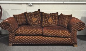 A modern three seater sofa, upholstered in dark red and burnt orange chenille type fabric,