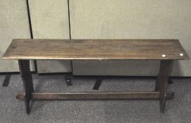 A vintage pine bench, with cross stretcher and shaped upright supports,