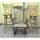A 20th century spindle back rocking chair together with two ladderback high chairs/bar stools