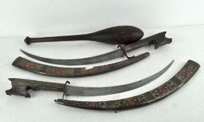 Two decorative brass and wood-mounted swords and scabbards, together with a turned wooden bat,