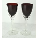 A pair of crimson coloured wine glasses, with spiral stems,