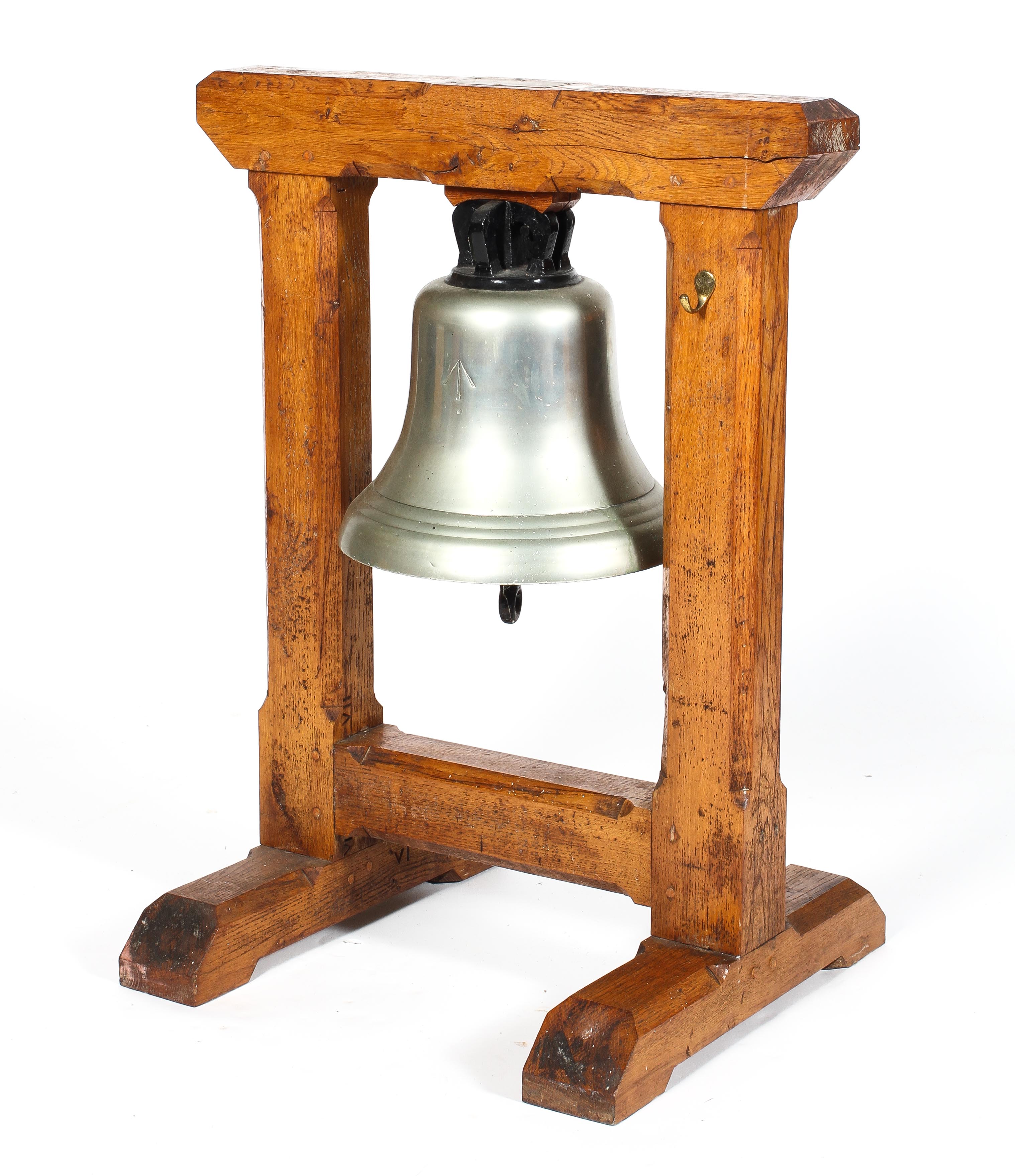 A large brass bell suspended from an oak frame,