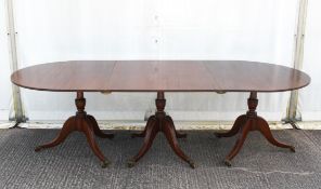 A George III mahogany extending pedestal dining table, on three pedestal supports,