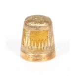 A 9ct gold thimble, with engraved and burnished decoration on a textured ground,