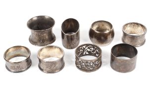 A collection of eight hallmarked silver napkin rings, various shapes and designs,