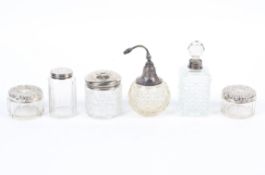 Six silver and white metal topped cut glass perfume bottles, a diffuser and assorted jars,