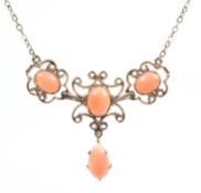 A yellow metal centrepiece necklace having a filigree design and set with oval cabochon peach