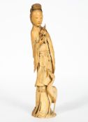 A Chinese ivory figure,19th century, of a maiden holding a peach branch,