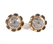 A pair of continental yellow metal earrings, each set with nine diamonds in a daisy cluster,