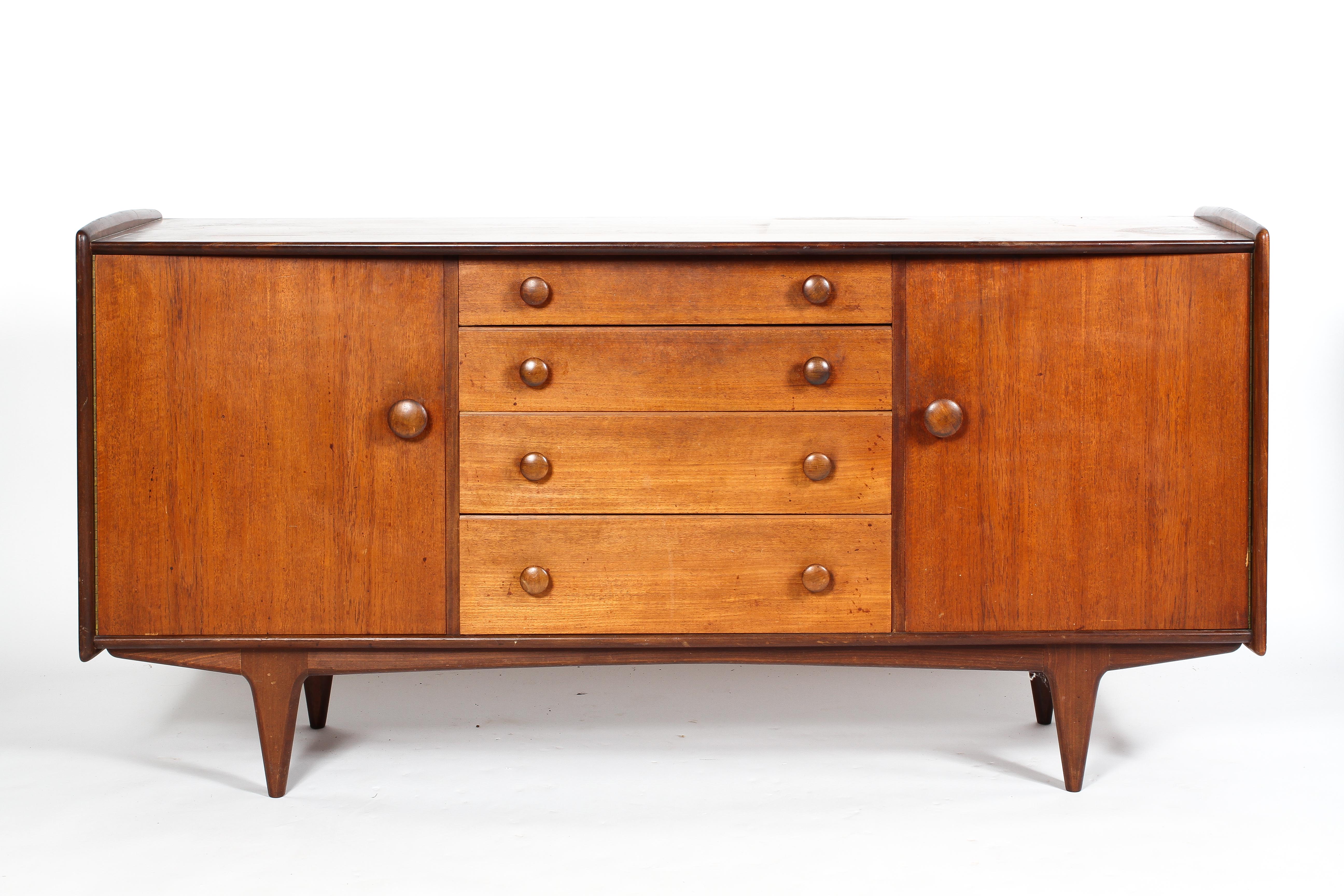 A mid century teak sideboard, with four central graduated short drawers,