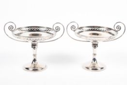 A pair of Edwardian silver tazzae, each with scrolling twin handles, pierced borders,