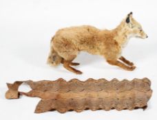 A taxidermy Red Fox together with a roll of snakeskin,