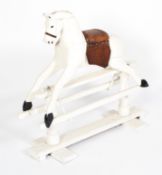 A wooden white painted rocking horse, early 20th century, with brown studded leather saddle,