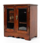 A Late Victorian oak smoker's cabinet, with two bevelled glass doors,