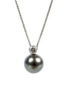 A diamond and black pearl drop pendant on a white metal chain, the clasp stamped 750,