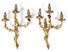 A pair of gilt metal wall lights, of scrolling foliate form,