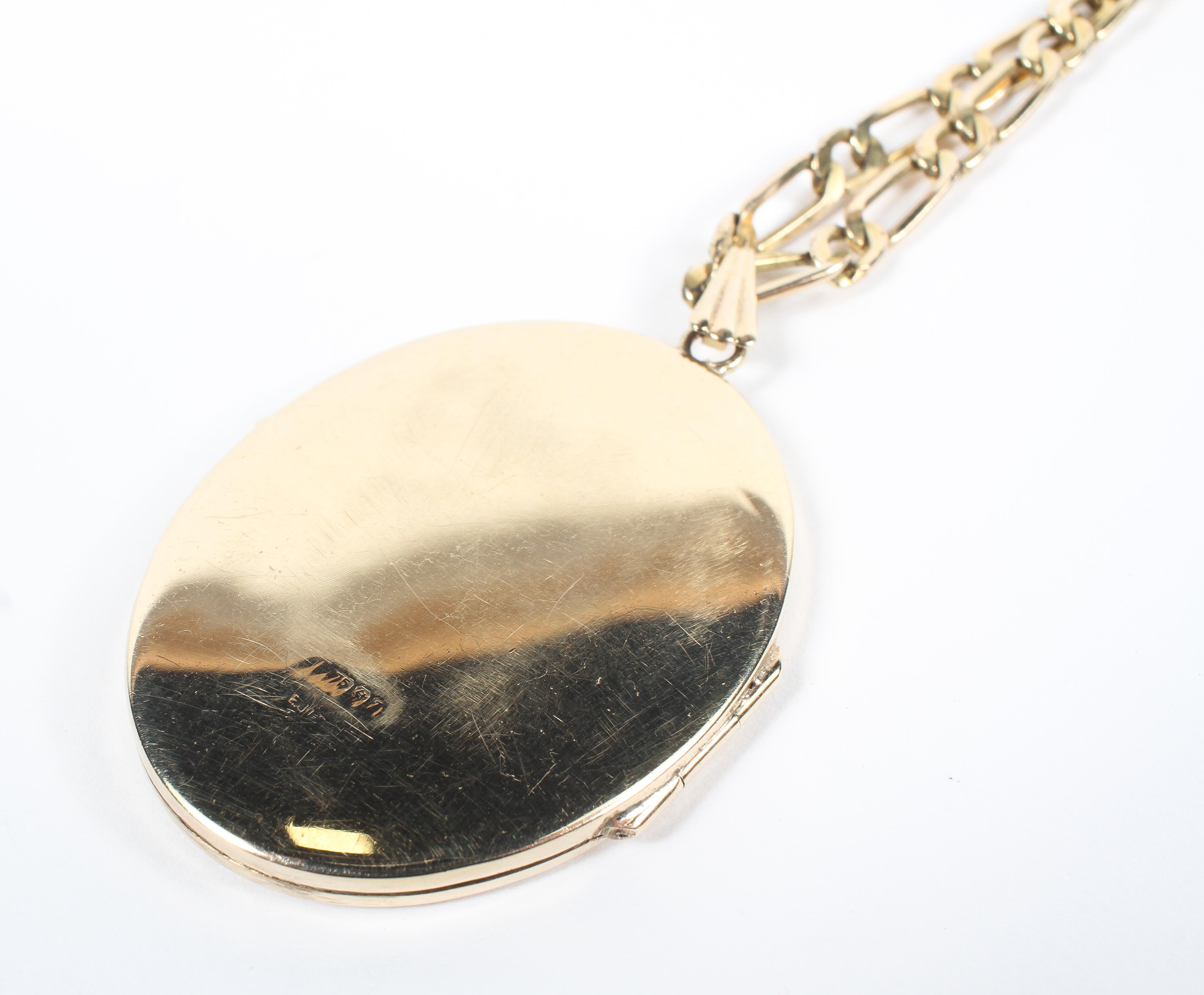 A yellow metal 40.0mm x 30.0mm oval locket pendant suspended from a 20 inch 1+1 Figaro chain. - Image 6 of 6