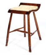 A 19th century mahogany stool, the curved seat upholstered in ivory coloured damask,