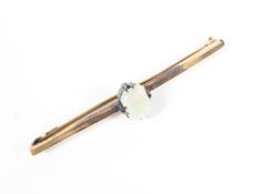 A yellow metal bar brooch having a central cabochon cut opal (untested) No hallmark;