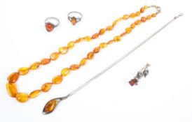 A collection of amber jewellery to include two rings, one brooch,