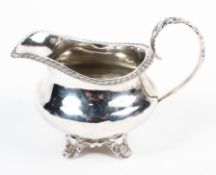 A William IV silver cream jug, gadrooned rim alongside an acanthus leaf handle,