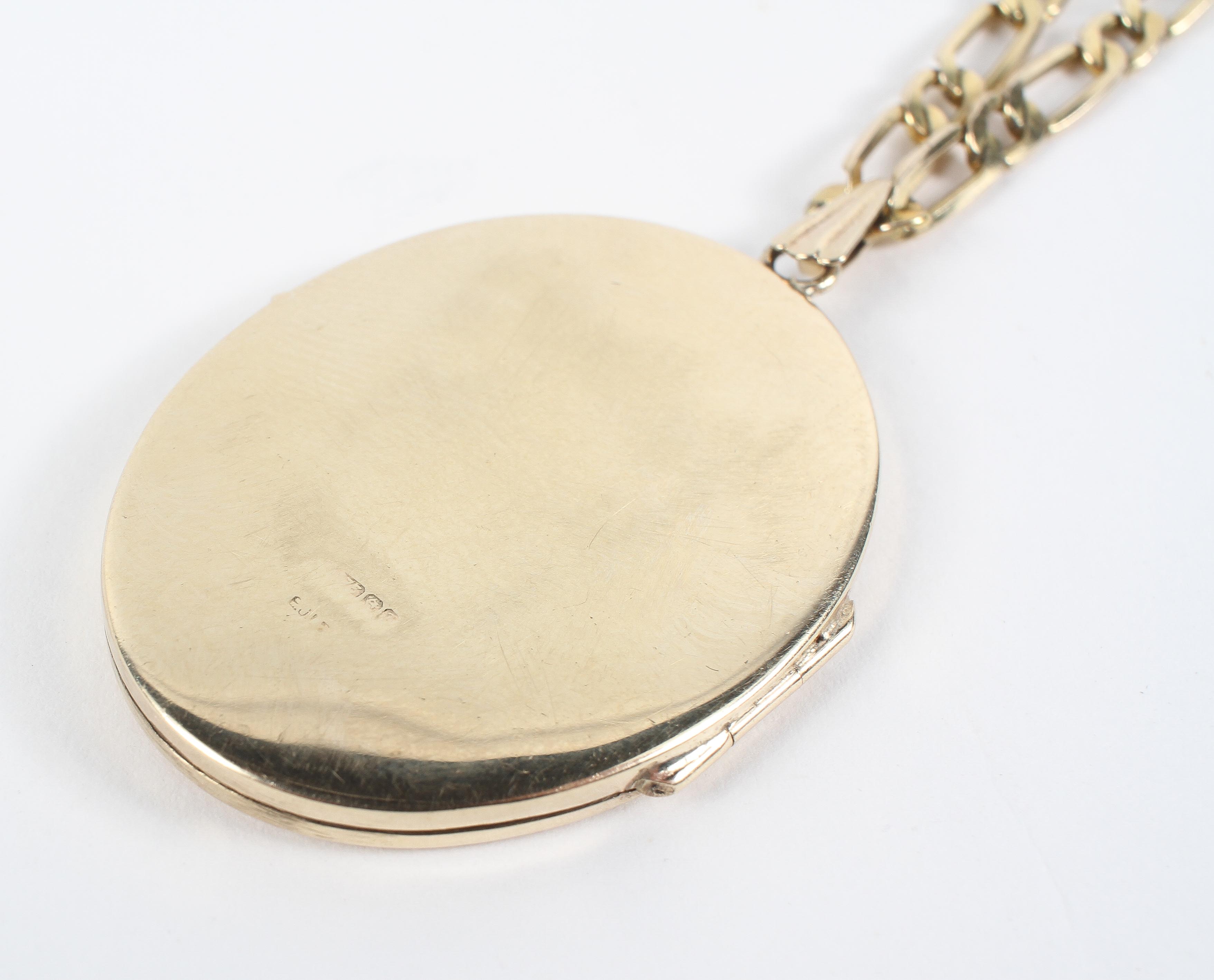 A yellow metal 40.0mm x 30.0mm oval locket pendant suspended from a 20 inch 1+1 Figaro chain. - Image 2 of 6