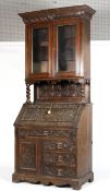 A Victorian carved oak bureau bookcase, carved with flower heads in lozenges,