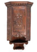 An 18th century carved walnut corner cupboard,