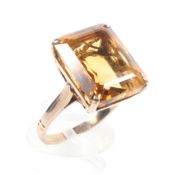 A yellow metal ring set with a rectangular cut citrine quartz