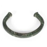 An antiquity style torque, probably bronze, with green verdi gris,