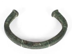 An antiquity style torque, probably bronze, with green verdi gris,