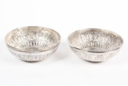 Two Middle Eastern silver dishes, each decorated with highly embossed and engraved decoration,
