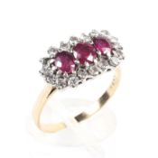 A yellow and white metal ring principally set with three oval cut rubies