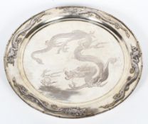 An early 20th century Chinese silver plated circular charger, on three bun feet,