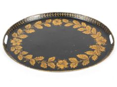 A Victorian toleware oval tray, gilt with leafy garland and flowers, within laurel border,