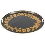 A Victorian toleware oval tray, gilt with leafy garland and flowers, within laurel border,