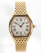 An 18ct gold ladies Cartier quartz wristwatch. Tonneau white dial with roman numerals.