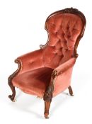 A Victorian button back armchair, with carved round top rail, scrolled arms,