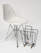 An Vitra Eames style chair of white plastic on a metal frame together with a magazine rack
