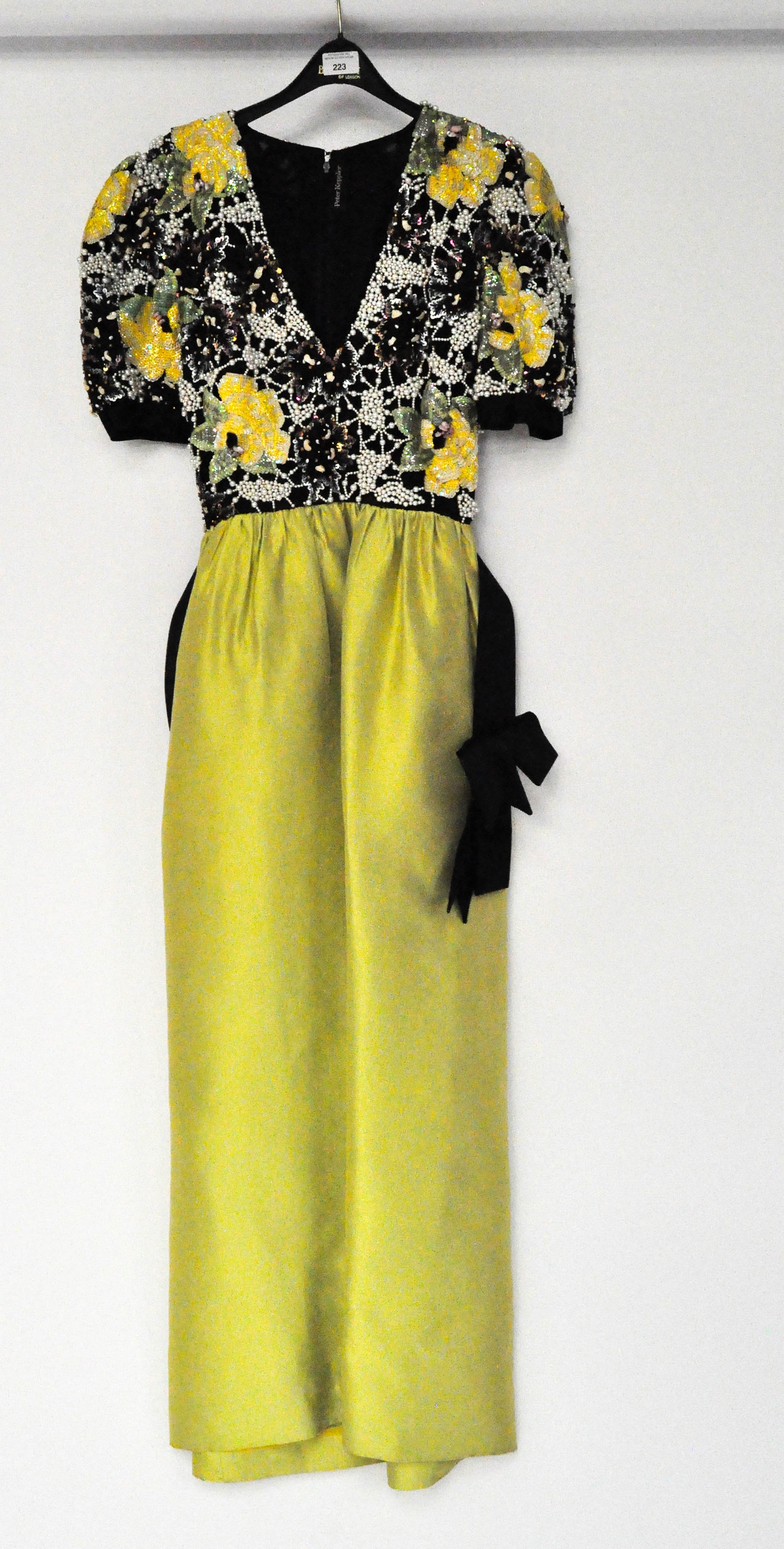 A vintage ladies evening dress with beaded top, black bow belt, and lime green full skirt,