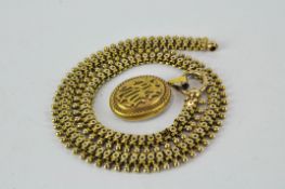 An unusual yellow metal chain with yellow photo locket, adorned with initials to front,